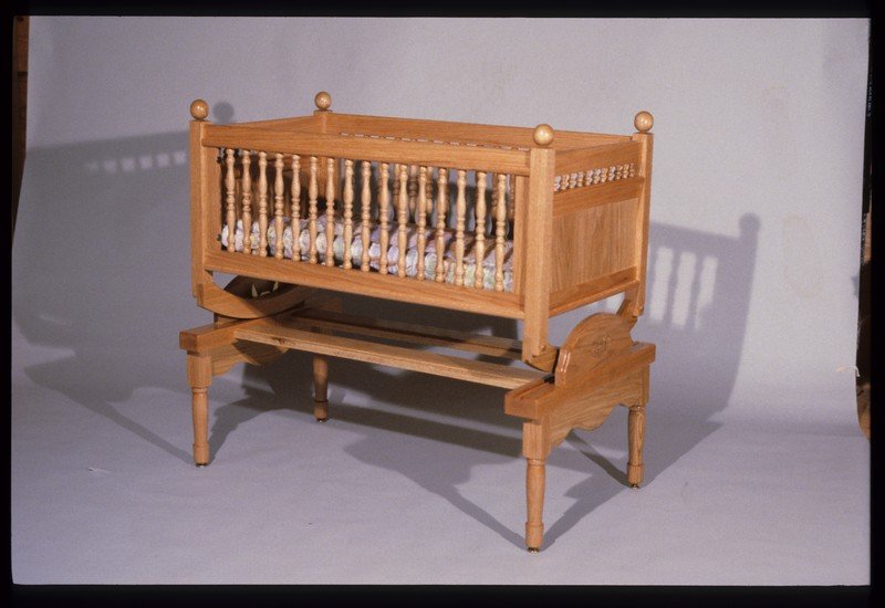 A Maple cradle, lockable gliding base. With spindle sides removed converts to a bench.